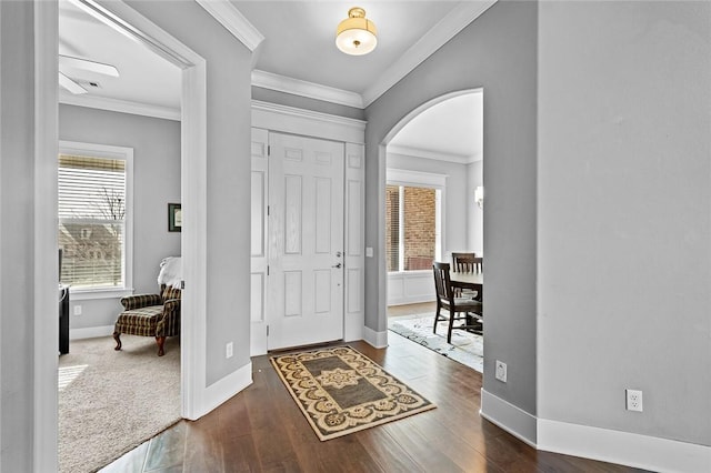 foyer featuring crown molding and dark carpet