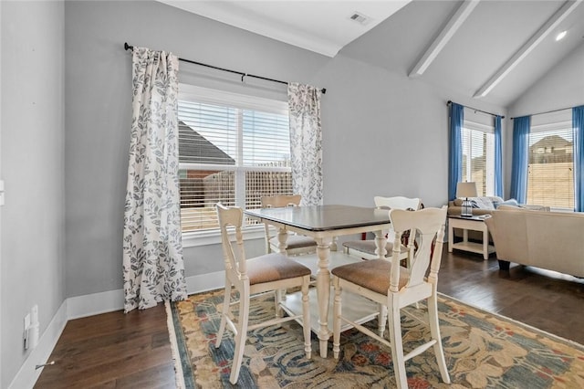 dining area featuring plenty of natural light, lofted ceiling with beams, and dark hardwood / wood-style floors