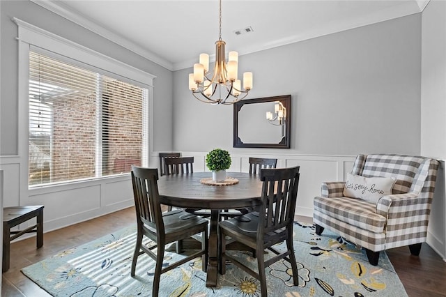 dining area with a wealth of natural light, hardwood / wood-style floors, and an inviting chandelier