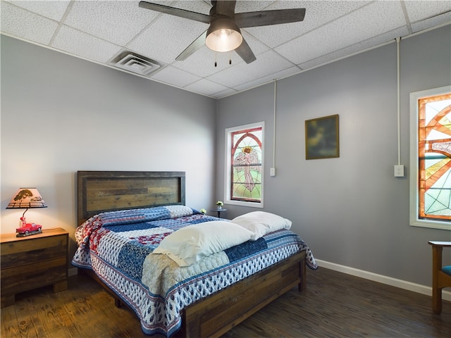 bedroom featuring a paneled ceiling, ceiling fan, and dark hardwood / wood-style flooring