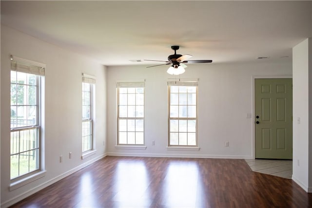 empty room featuring ceiling fan, baseboards, and wood finished floors