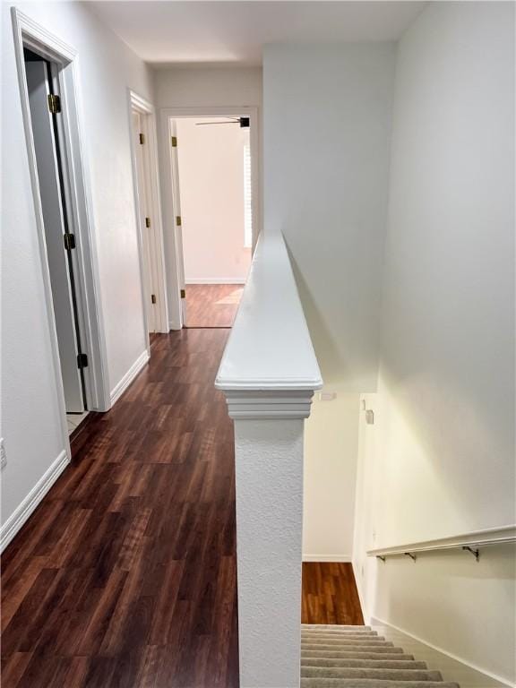 hallway with dark wood-style floors and baseboards