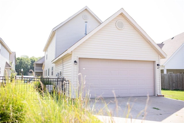 view of side of property featuring a garage and fence