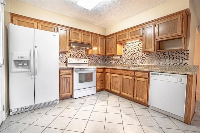 kitchen with decorative backsplash, white appliances, a textured ceiling, and light tile patterned floors