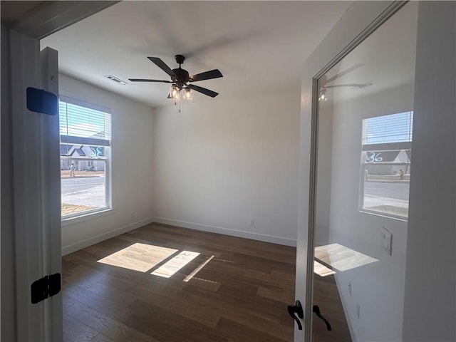 spare room featuring ceiling fan and dark wood-type flooring