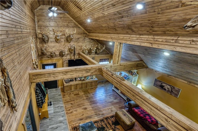 interior space featuring ceiling fan, wooden walls, wooden ceiling, and hardwood / wood-style flooring