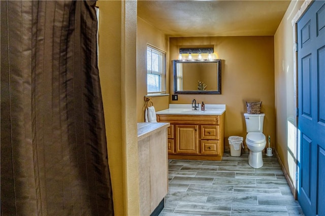 bathroom with toilet, wood-type flooring, and vanity