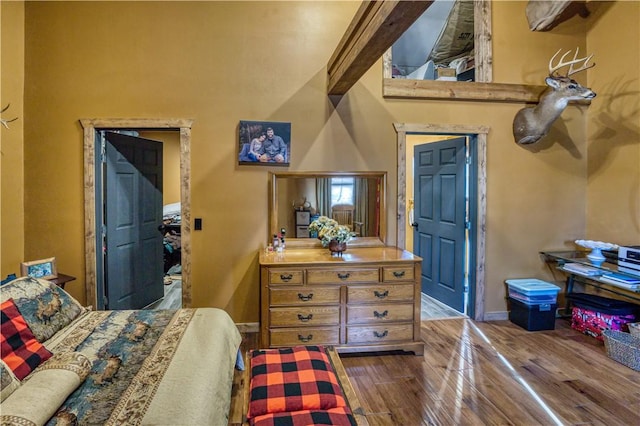 bedroom featuring a high ceiling and hardwood / wood-style floors