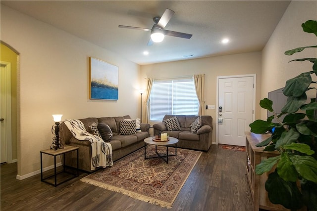 living room featuring ceiling fan and dark hardwood / wood-style flooring