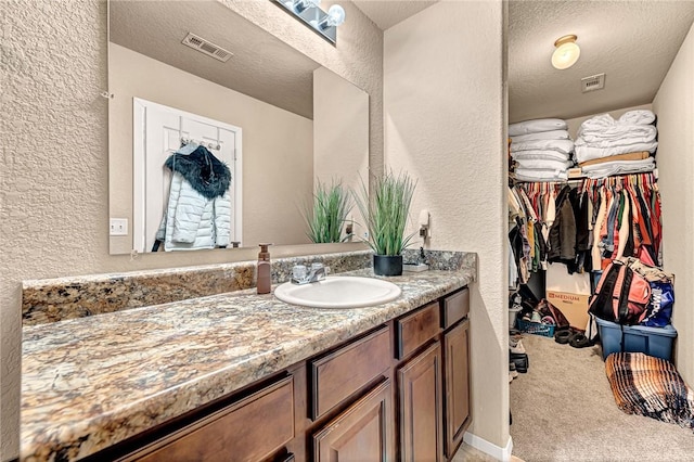 bathroom with a textured ceiling and vanity