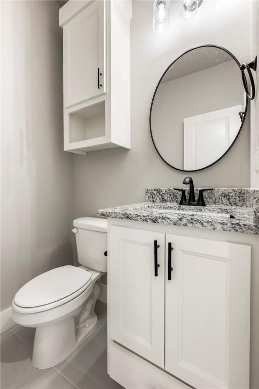 bathroom with tile patterned flooring, vanity, and toilet