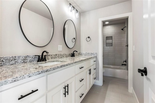 full bathroom with tile patterned flooring, vanity, toilet, and tiled shower / bath