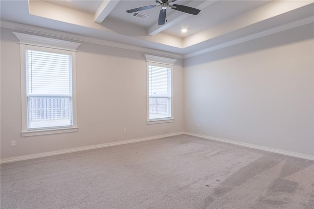 carpeted empty room featuring beamed ceiling, ceiling fan, a raised ceiling, and crown molding