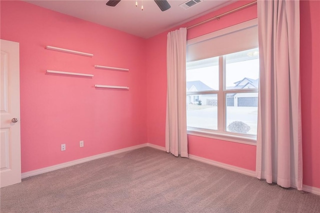 carpeted spare room featuring ceiling fan