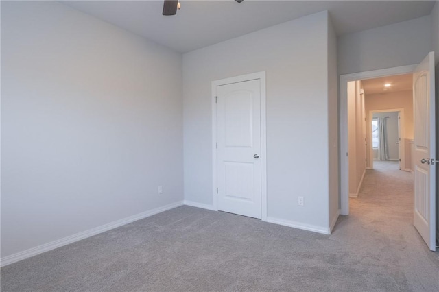 unfurnished bedroom featuring light colored carpet and ceiling fan