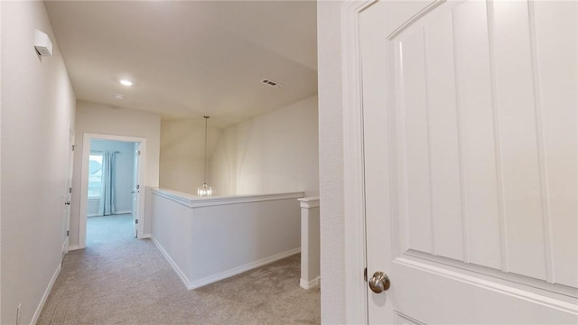 hallway featuring light colored carpet