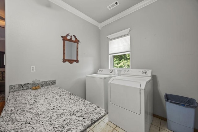 clothes washing area featuring light tile patterned flooring, laundry area, visible vents, washer and dryer, and ornamental molding