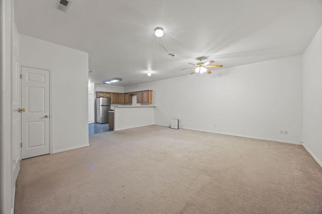 unfurnished living room featuring light colored carpet, visible vents, ceiling fan, and baseboards