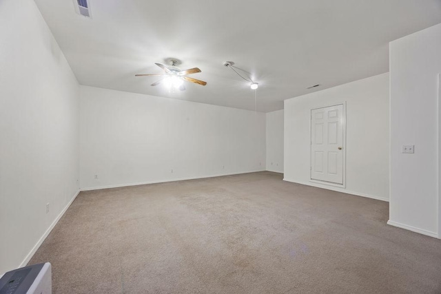 carpeted empty room featuring visible vents, ceiling fan, and baseboards