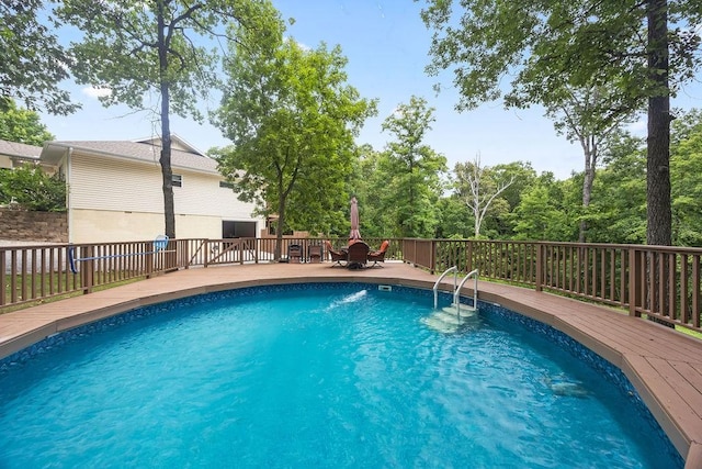 view of pool with outdoor dining space and a wooden deck