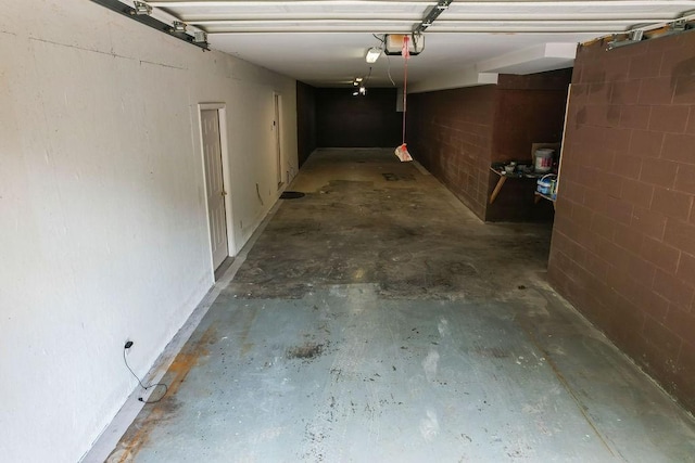 garage with concrete block wall and a garage door opener