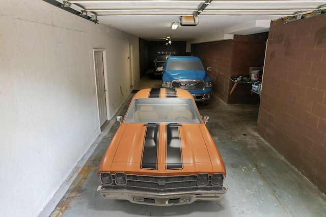 garage featuring a garage door opener and concrete block wall