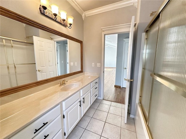 full bathroom with ornamental molding, an enclosed shower, vanity, and tile patterned floors