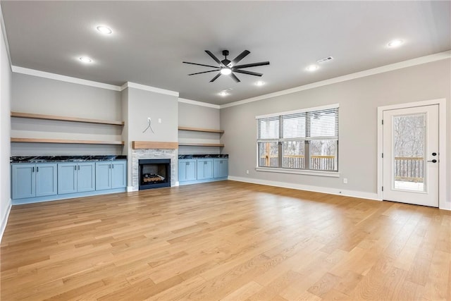 unfurnished living room featuring a fireplace, light hardwood / wood-style flooring, ceiling fan, and crown molding