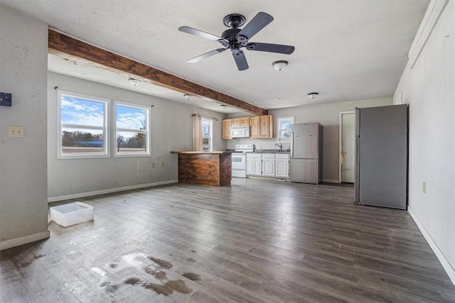 unfurnished living room featuring beam ceiling, ceiling fan, sink, hardwood / wood-style floors, and a textured ceiling