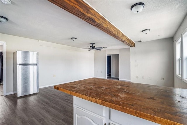 kitchen with ceiling fan, stainless steel fridge, a textured ceiling, dark hardwood / wood-style flooring, and white cabinetry