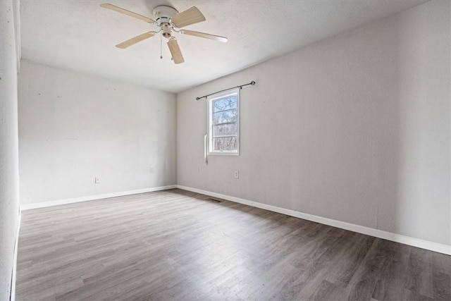 spare room with ceiling fan and wood-type flooring