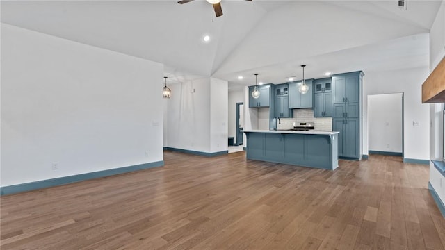 unfurnished living room with ceiling fan, sink, dark wood-type flooring, and high vaulted ceiling