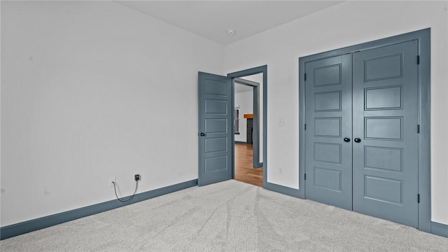 unfurnished bedroom with light carpet and a closet