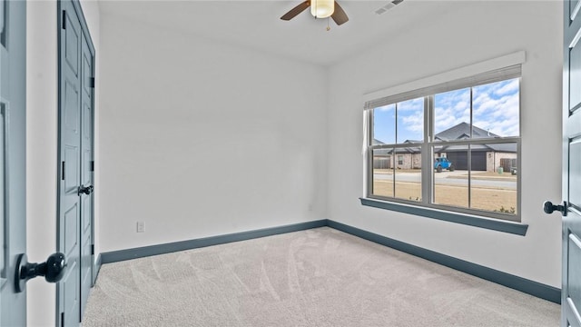 carpeted spare room with ceiling fan