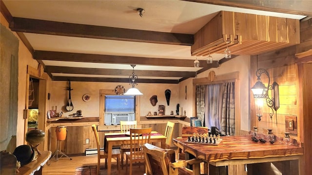 dining room with beam ceiling, cooling unit, a baseboard heating unit, and wood walls