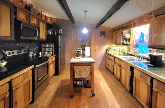 kitchen featuring pendant lighting, sink, appliances with stainless steel finishes, beamed ceiling, and tile counters