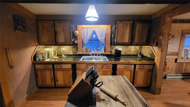 kitchen featuring decorative light fixtures, tasteful backsplash, a baseboard heating unit, and sink