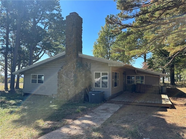 rear view of property with a deck and central air condition unit