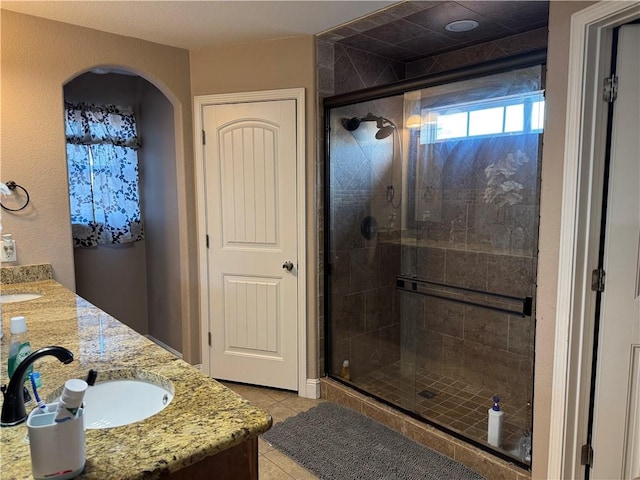 bathroom with tile patterned flooring, vanity, and a shower with shower door