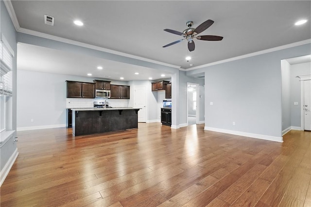 unfurnished living room with ceiling fan, ornamental molding, and light hardwood / wood-style floors