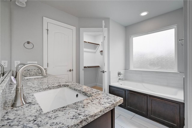 bathroom with vanity and a tub