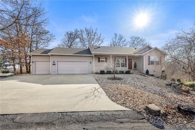 single story home with a porch and a garage