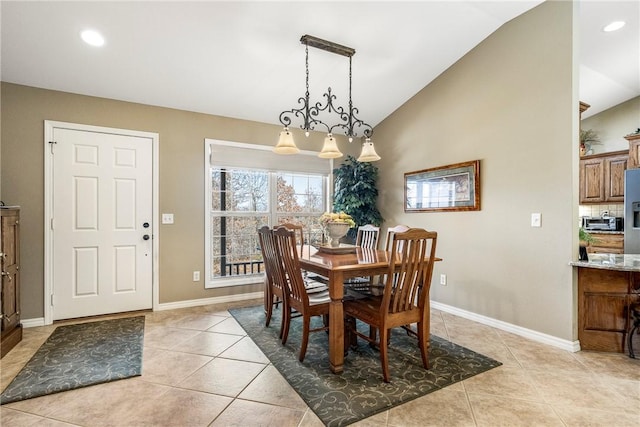 dining space featuring lofted ceiling, light tile patterned flooring, and a notable chandelier