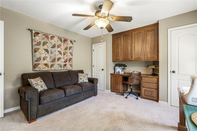 carpeted home office featuring ceiling fan