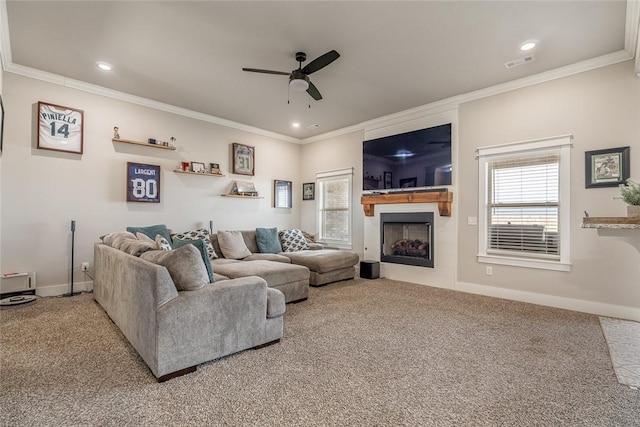 living room featuring carpet floors, ceiling fan, and crown molding