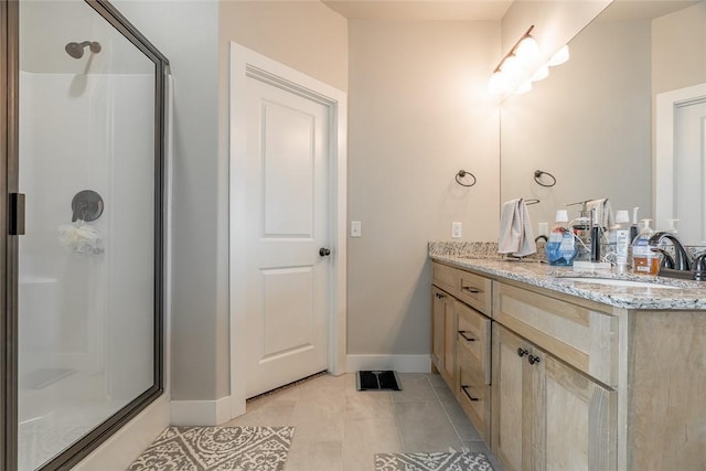 bathroom featuring tile patterned flooring, vanity, and walk in shower