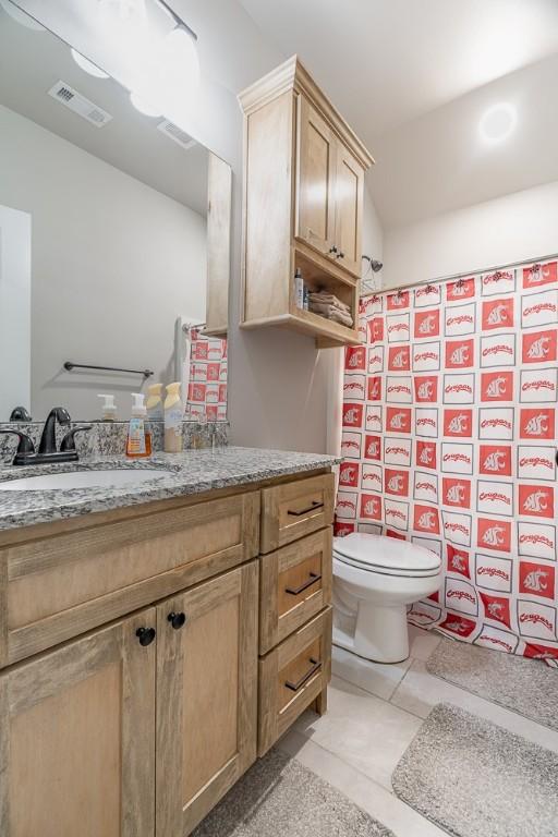 bathroom featuring tile patterned floors, vanity, and toilet