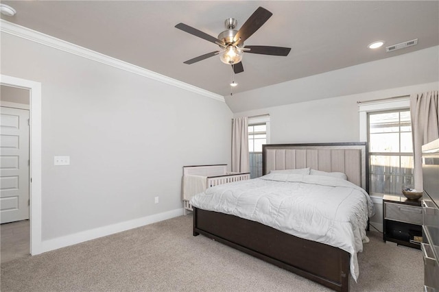 carpeted bedroom featuring ceiling fan, vaulted ceiling, and ornamental molding