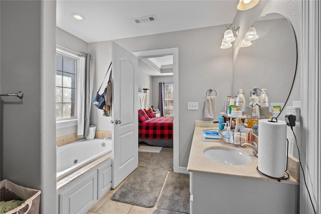 bathroom with tile patterned floors, a tub to relax in, and vanity