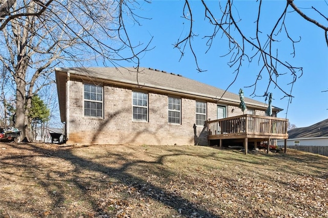 back of house with a lawn and a deck